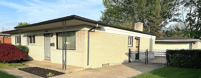 view of side of home with a chimney, fence, a garage, and an outdoor structure