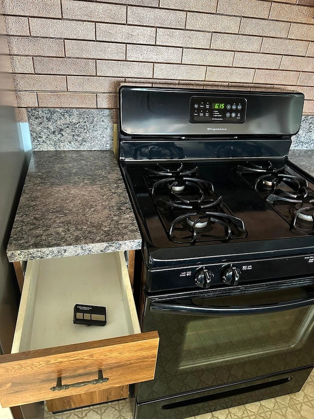 kitchen view of black gas range oven and backsplash