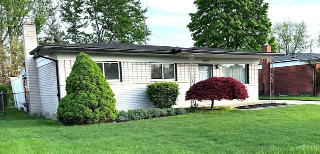 view of front of house featuring a chimney and a front lawn