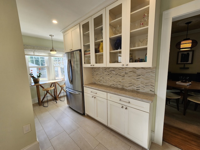 2414 Yale Ave, Royal Oak, MI 48067 - kitchen featuring freestanding refrigerator, tasteful backsplash, light stone countertops, glass insert cabinets, and hanging light fixtures