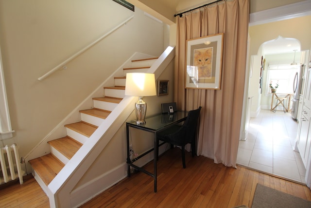 2414 Yale Ave, Royal Oak, MI 48067 - staircase featuring hardwood / wood-style flooring, arched walkways, radiator heating unit, and baseboards