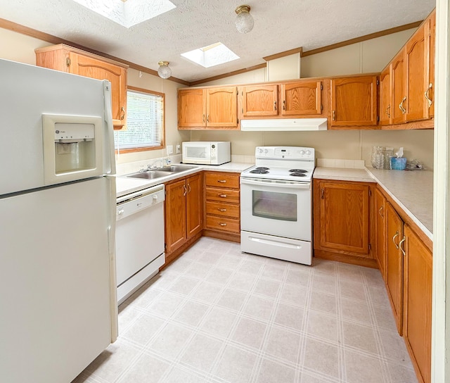 kitchen featuring white appliances, a skylight, a sink, crown molding, and light countertops