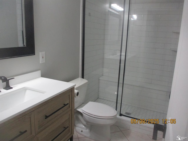full bath with a stall shower, toilet, vanity, and tile patterned floors