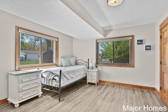 bedroom featuring baseboards and light wood finished floors
