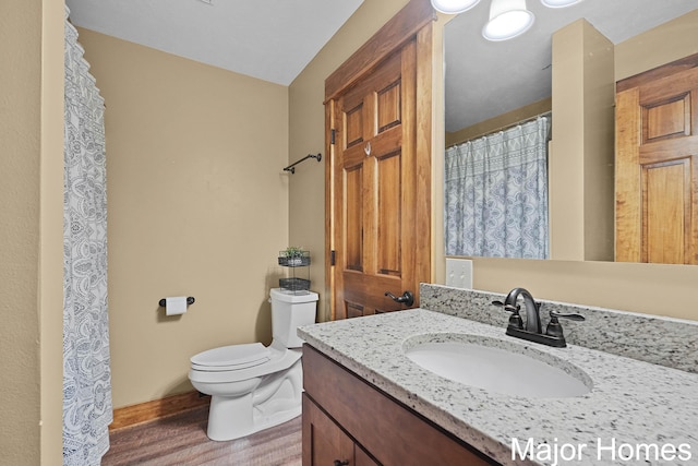 full bathroom featuring wood finished floors, toilet, and vanity