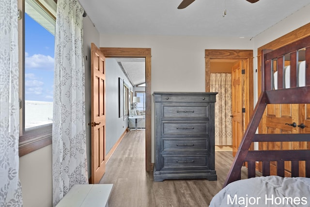 bedroom featuring wood finished floors, baseboards, and a ceiling fan