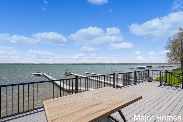 wooden deck featuring a water view and a boat dock