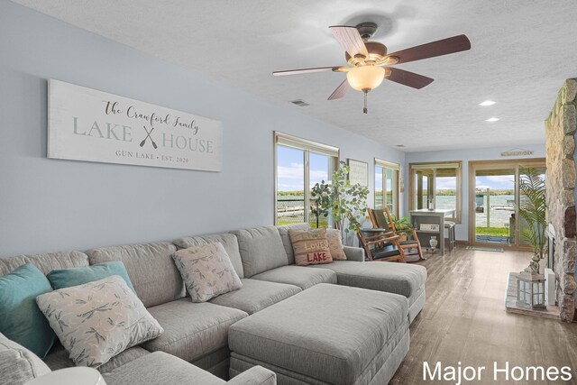 living area featuring plenty of natural light, a textured ceiling, ceiling fan, wood finished floors, and recessed lighting