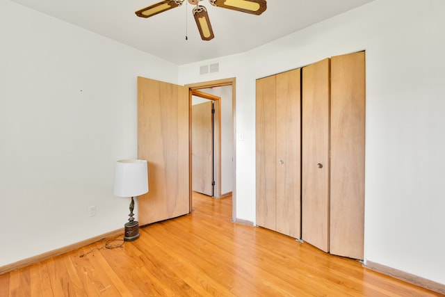 unfurnished bedroom with light wood-style floors, a closet, baseboards, and a ceiling fan
