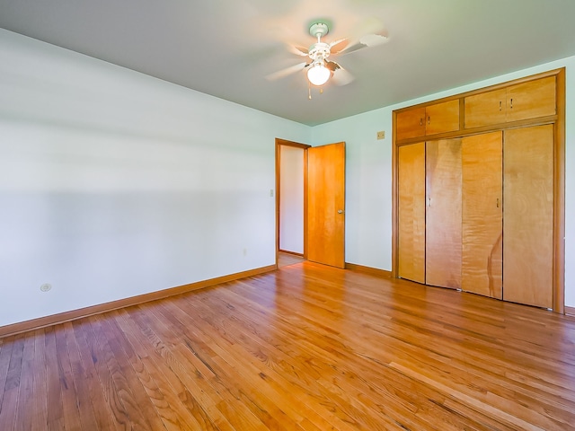 unfurnished bedroom featuring baseboards, light wood-style floors, a closet, and ceiling fan