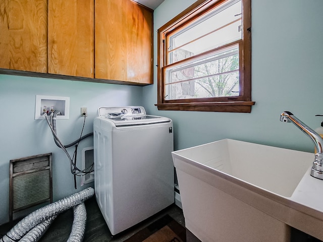 clothes washing area featuring washer / clothes dryer and cabinet space