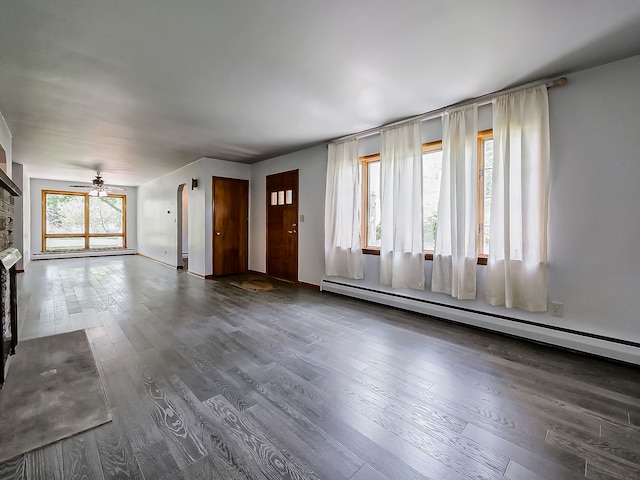 unfurnished living room with baseboard heating, wood finished floors, and ceiling fan