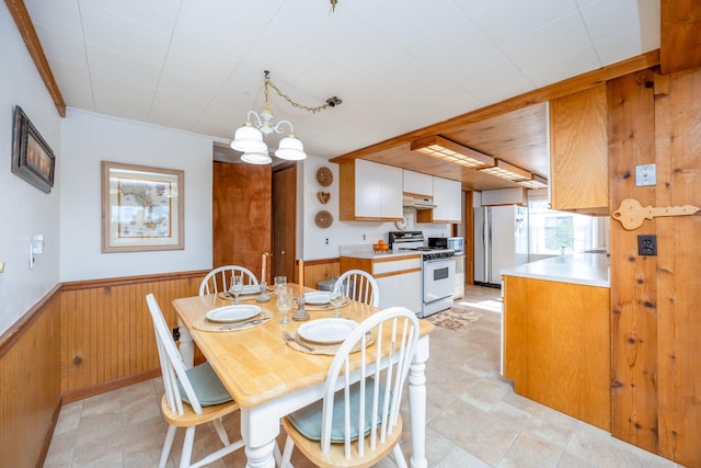 10401 N Chippewa Dr, Evart, MI 49631 - dining area featuring wainscoting, wood walls, and a chandelier