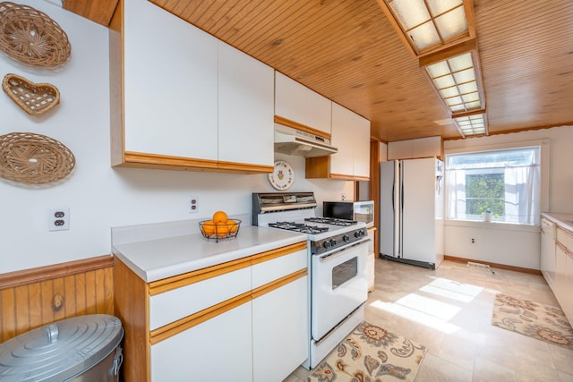 10401 N Chippewa Dr, Evart, MI 49631 - kitchen featuring white appliances, under cabinet range hood, wooden ceiling, light countertops, and white cabinetry