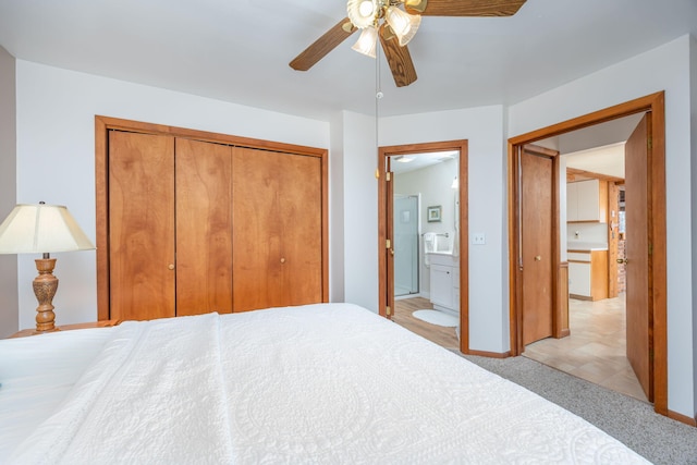 10401 N Chippewa Dr, Evart, MI 49631 - bedroom with a closet, ensuite bath, light colored carpet, ceiling fan, and baseboards