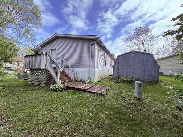 back of property featuring a yard, a storage shed, an outdoor structure, and a deck