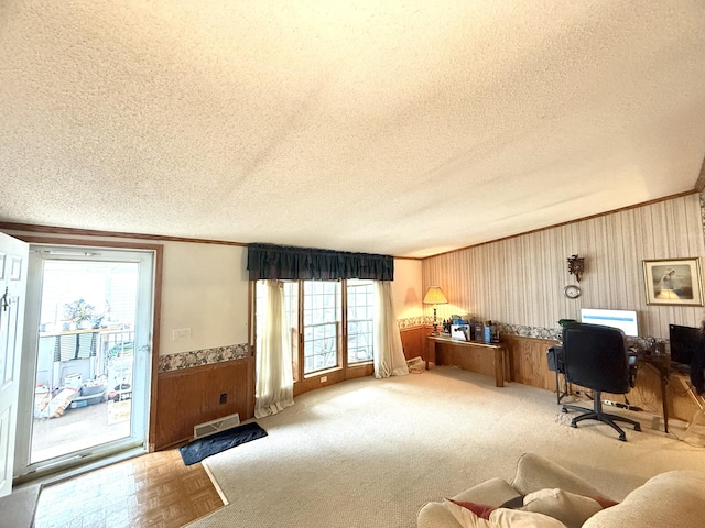 office featuring a textured ceiling, wood walls, a wainscoted wall, and ornamental molding