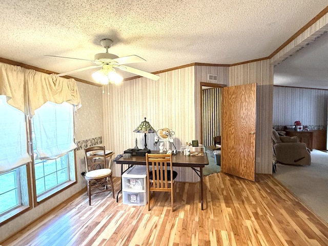 home office with ornamental molding, wood finished floors, a textured ceiling, ceiling fan, and wallpapered walls
