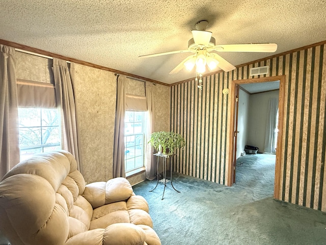 sitting room with carpet floors, a ceiling fan, a textured ceiling, and ornamental molding