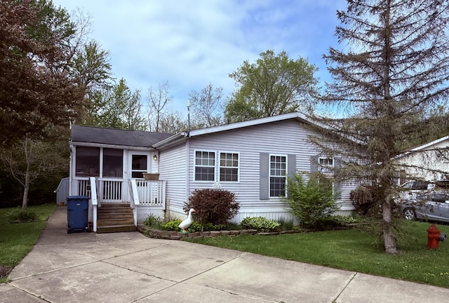 view of front facade with a sunroom and a front yard