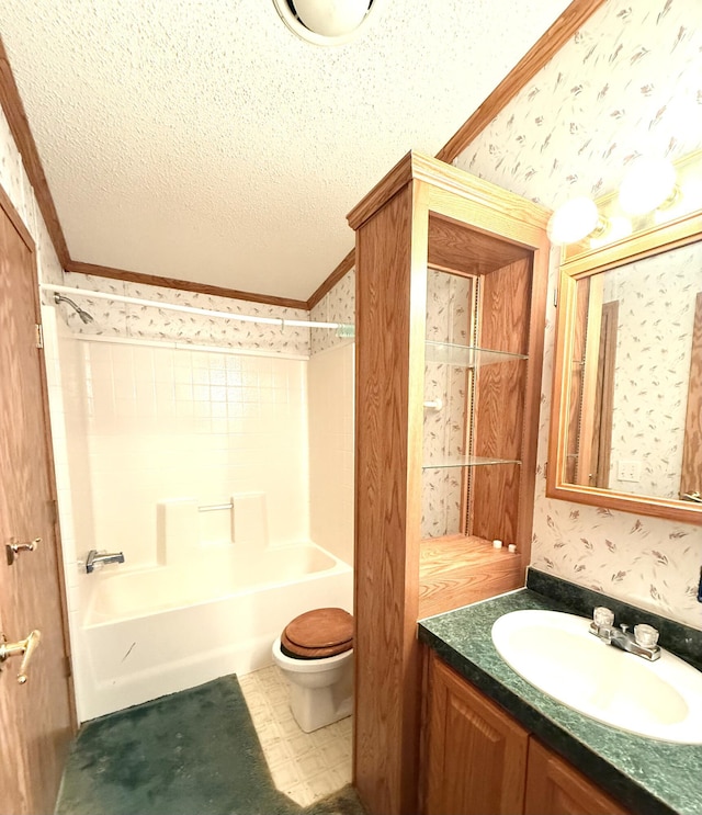 bathroom with ornamental molding, wallpapered walls, toilet, vanity, and a textured ceiling