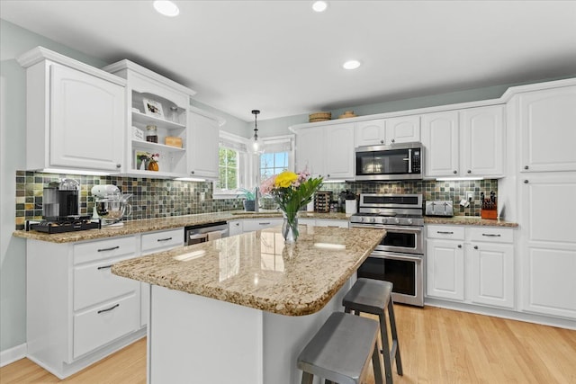 3645 Sandbar Dr, Commerce Twp, MI 48382 - kitchen with stainless steel appliances, white cabinetry, light wood-style floors, and recessed lighting