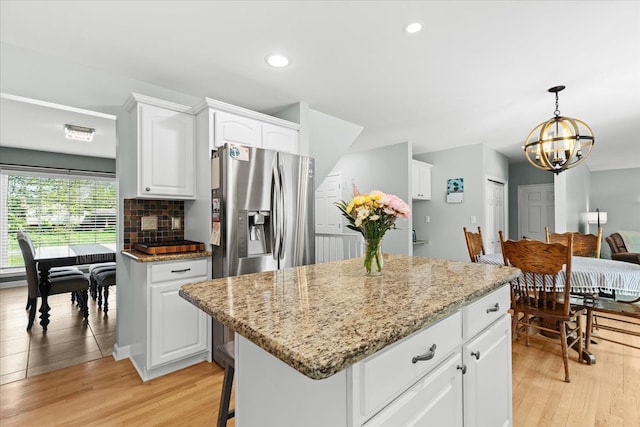 3645 Sandbar Dr, Commerce Twp, MI 48382 - kitchen with a chandelier, light stone counters, white cabinets, light wood-style floors, and recessed lighting