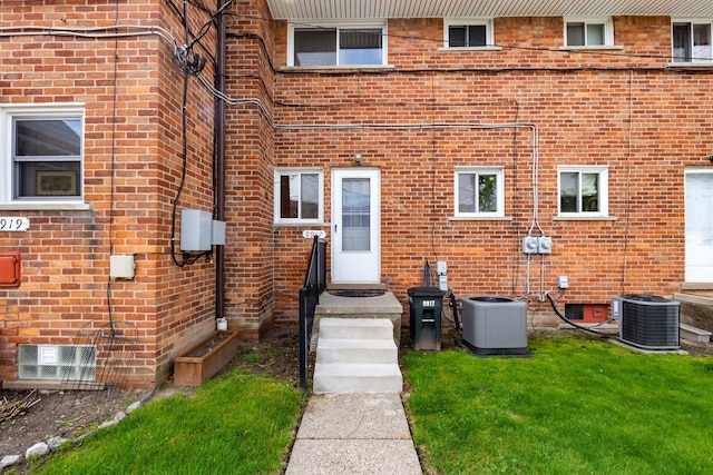 9917 Middlebelt Rd, Livonia, MI 48150 - doorway to property featuring central air condition unit, brick siding, and a yard