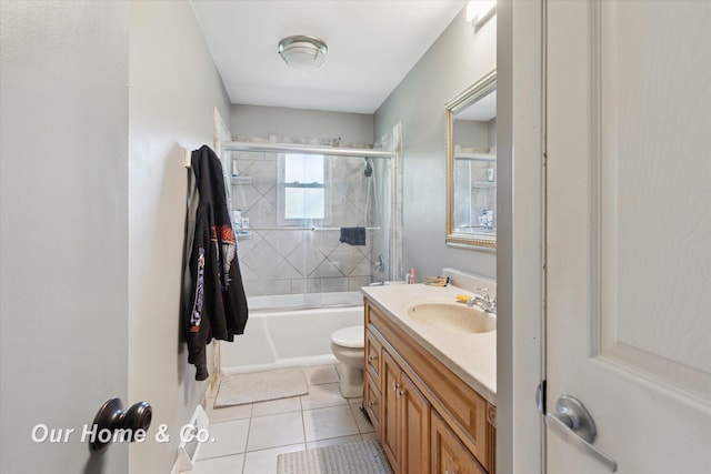 bathroom with tile patterned floors, vanity, combined bath / shower with glass door, and toilet