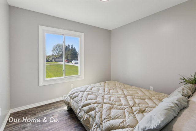 bedroom with baseboards and wood finished floors