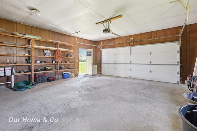 garage featuring wood walls and a garage door opener