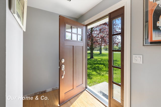 doorway to outside featuring light wood finished floors and baseboards