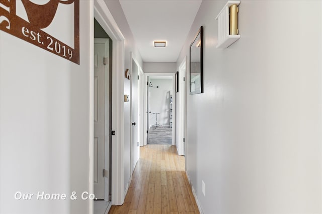 hallway with light wood finished floors and baseboards