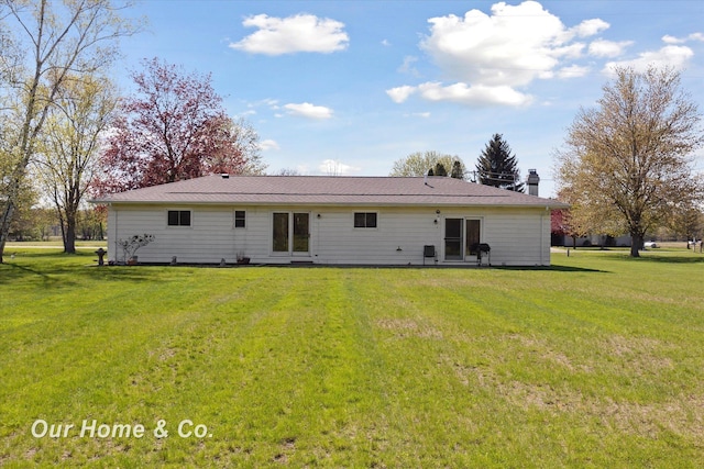 back of property with a yard and a chimney