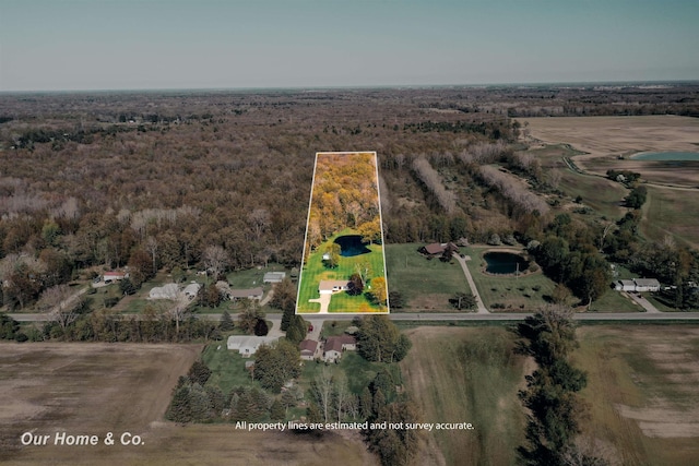 aerial overview of property's location with property parcel outlined, rural landscape, and a heavily wooded area
