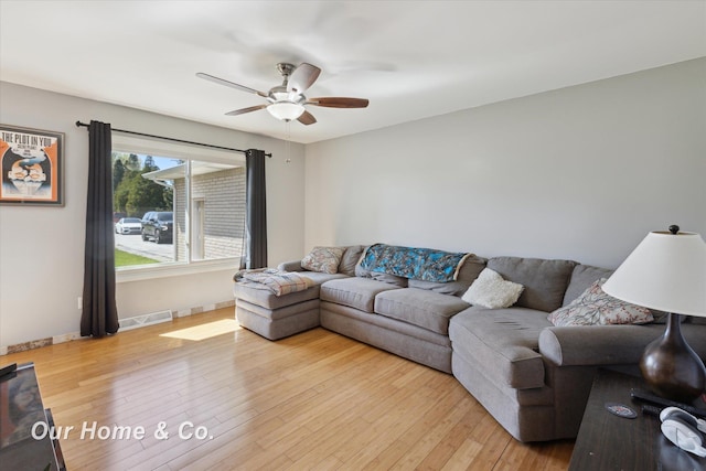 living room with ceiling fan, light wood-type flooring, and baseboards