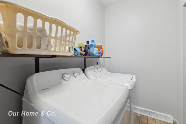 washroom with washing machine and clothes dryer and baseboards