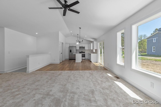 unfurnished living room with light carpet, lofted ceiling, healthy amount of natural light, recessed lighting, and a ceiling fan