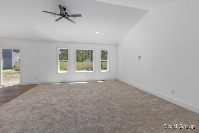 carpeted empty room featuring vaulted ceiling, baseboards, and a ceiling fan