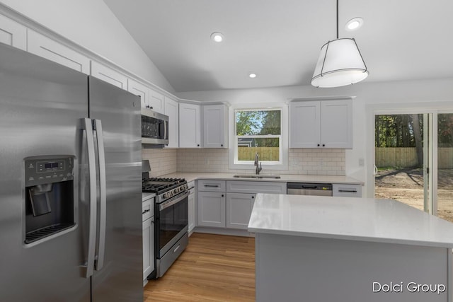 kitchen with stainless steel appliances, a sink, light countertops, backsplash, and recessed lighting