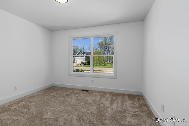 carpeted spare room featuring baseboards