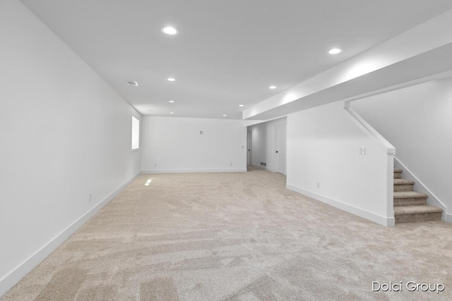 basement with light carpet, recessed lighting, stairway, and baseboards