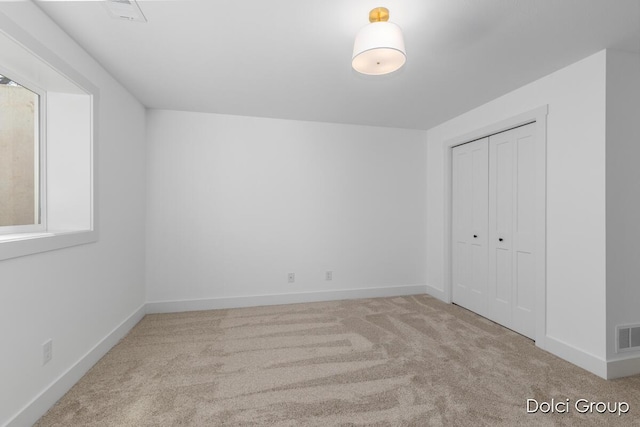 unfurnished bedroom featuring carpet flooring, baseboards, and a closet