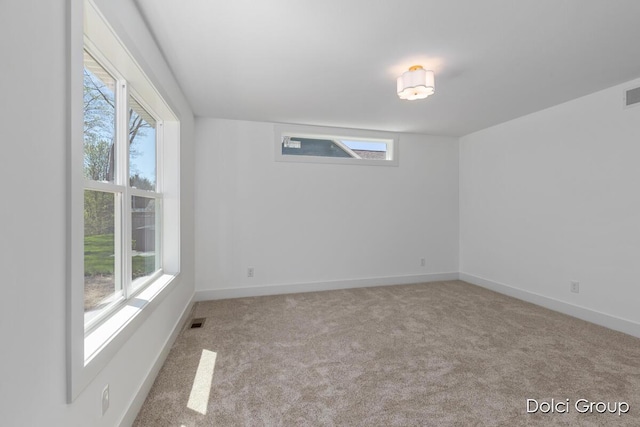 empty room with plenty of natural light, carpet, and baseboards