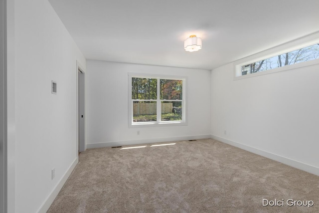 spare room with carpet and baseboards
