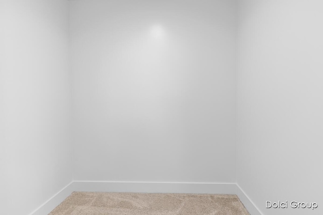 carpeted empty room featuring baseboards