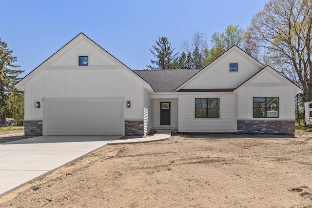 modern inspired farmhouse with stone siding, a garage, concrete driveway, and a shingled roof