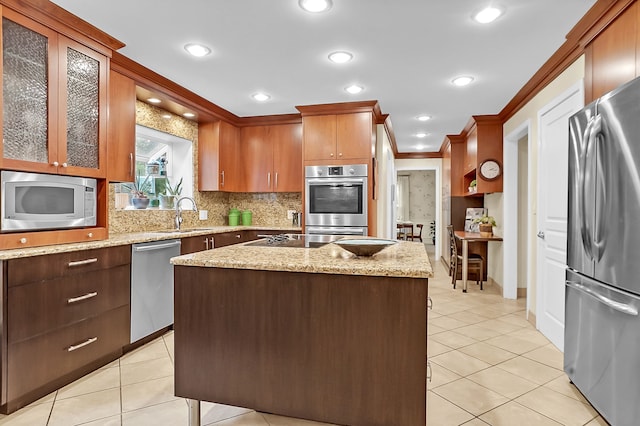 kitchen with stainless steel appliances, a sink, tasteful backsplash, light tile patterned floors, and ornamental molding