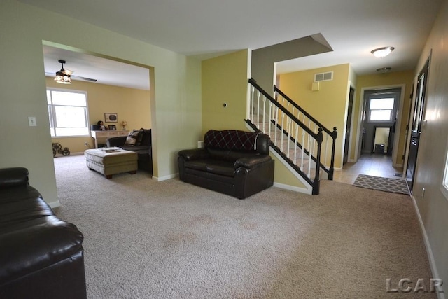 1872 Allan St, Adrian, MI 49221 - living room featuring healthy amount of natural light, stairway, ceiling fan, and carpet flooring