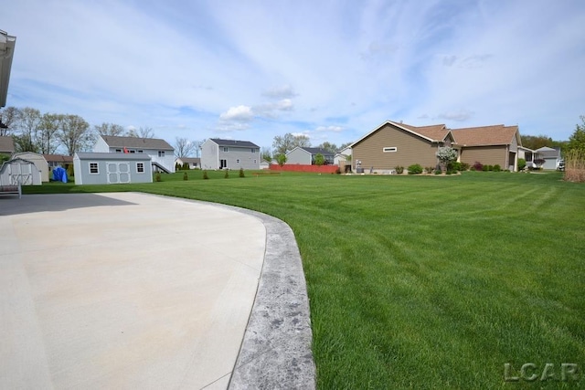 1872 Allan St, Adrian, MI 49221 - view of grassy yard with a storage unit, a residential view, and an outbuilding